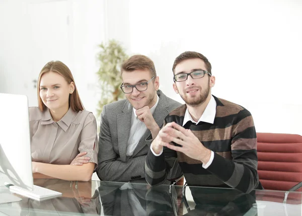 Sorrindo equipe de negócios sentado na mesa — Fotografia de Stock