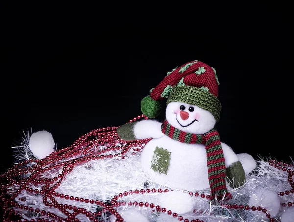 Leuk speelgoed sneeuwpop en kerst decoraties op een zwarte achtergrond — Stockfoto