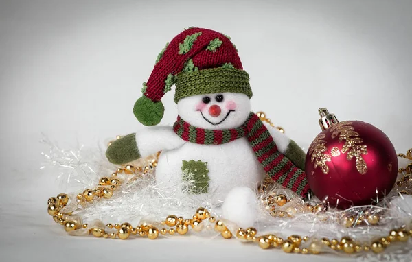 Cute toy snowman and various Christmas decorations on a white b — Stock Photo, Image