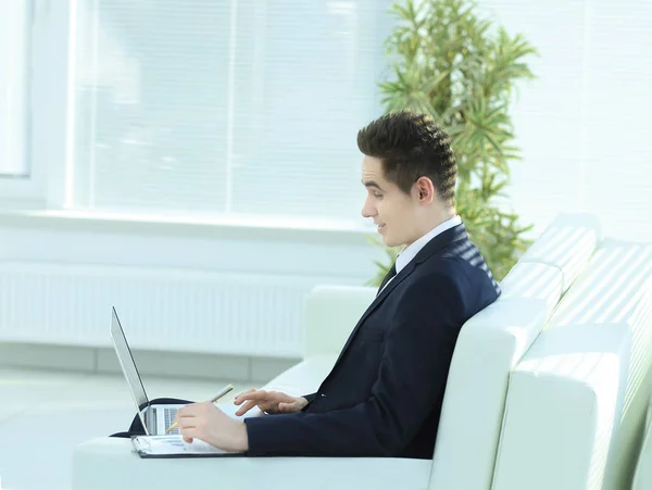 Zelfverzekerde zakenman werkt aan laptop zittend in de ruime — Stockfoto