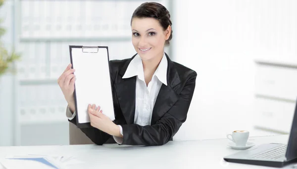 Executiva mulher de negócios mostrando folha em branco, sentado em sua mesa — Fotografia de Stock