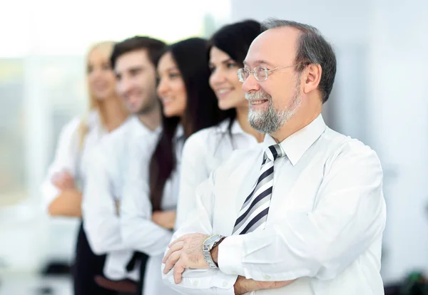 Взрослый уверенный бизнесмен на фоне деловой команды — стоковое фото
