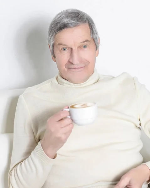 Närbild. lugn äldre man med en kopp kaffe — Stockfoto