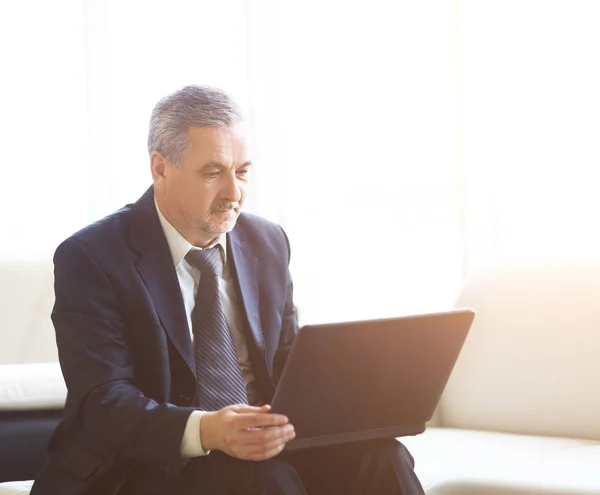 Businessman in the office with laptop sits and works — Stock Photo, Image