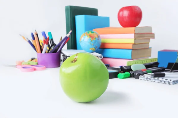 Primeiro plano uma maçã verde no fundo de material escolar .photo com espaço de cópia — Fotografia de Stock