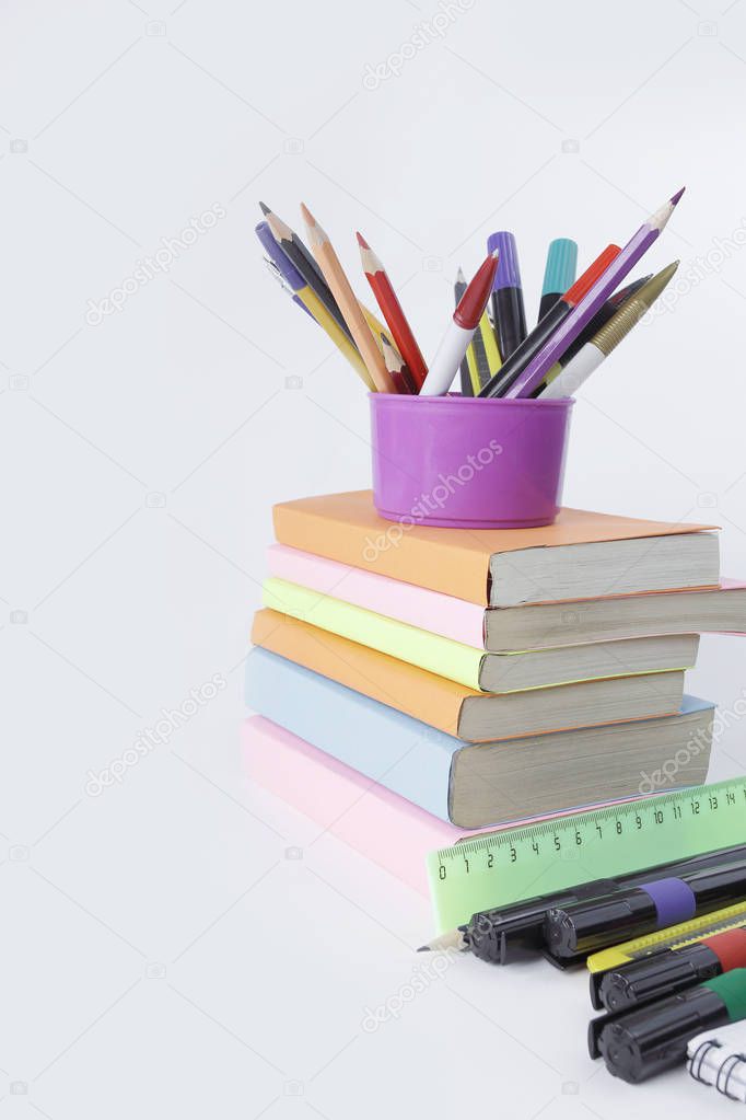 books and a variety of office supplies on white background .phot