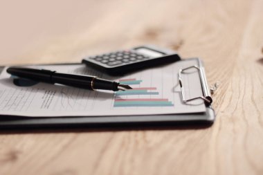 yakın çekim. kalem, hesap makinesi ve ahşap masa panoda. İşletme