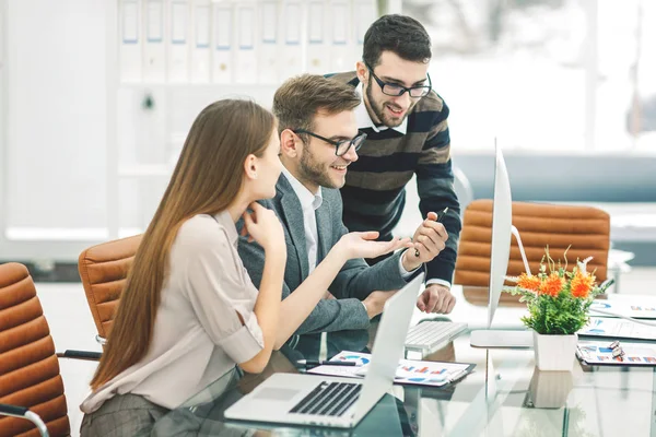 Equipo profesional de negocios está desarrollando un nuevo proyecto, sentado detrás de un escritorio en una oficina moderna . — Foto de Stock