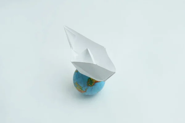 Łódź papieru na globe.isolated na białym tle. — Zdjęcie stockowe
