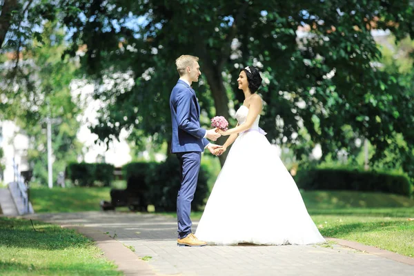 Šťastný pár stojící v parku na den svatby. — Stock fotografie