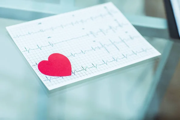 Concept van gezondheid: rood papier hart op het elektrocardiogram, de cardioloog — Stockfoto