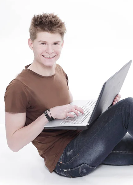 Bonito jovem relaxante homem usando laptop e deitado no sofá — Fotografia de Stock