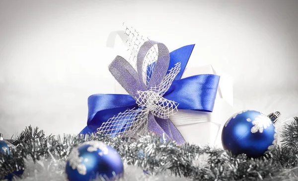 Cadeau de Noël et boules de Noël bleues sur un dos blanc festif — Photo