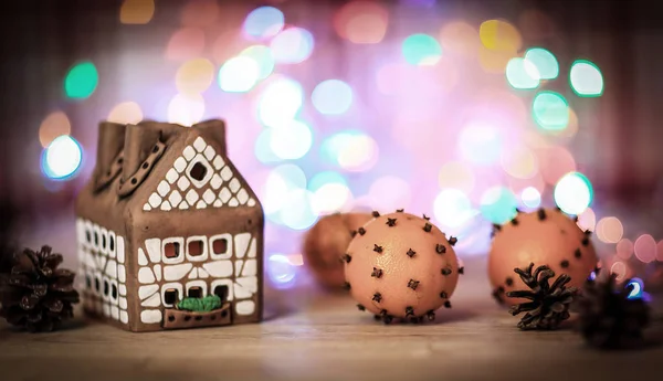 クリスマステーブルのジンジャーブレッドハウスとオレンジ — ストック写真
