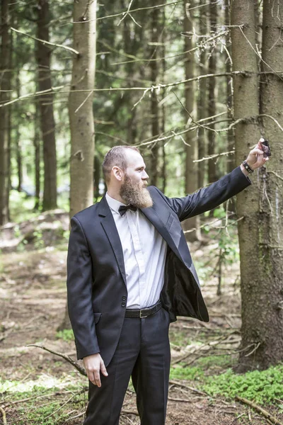 Бизнесмен делает селфи на фоне соснового леса . — стоковое фото