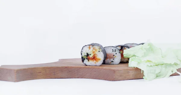 Rouleaux de sushi sur une planche à découper.isolé sur blanc — Photo