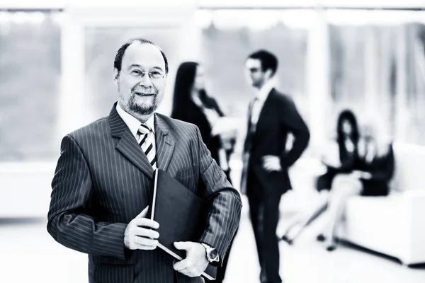 Retrato de empresario exitoso con documentos en el fondo del equipo de negocios y la oficina. foto en blanco y negro —  Fotos de Stock