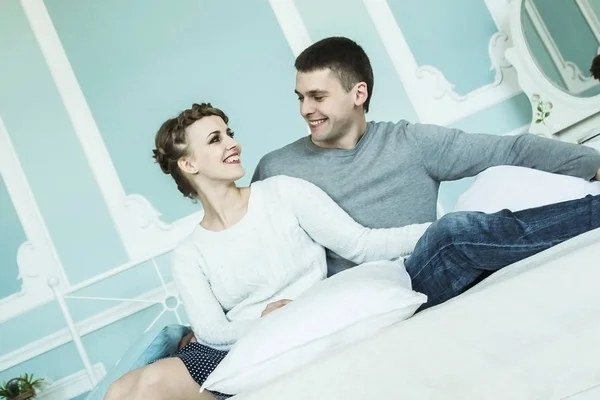 Szerető pár ül az ágyon a hálószobában — Stock Fotó