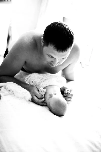 Happy father holding hands the newborn baby, black and white photo — Stock Photo, Image