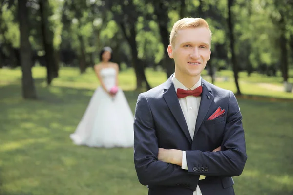 portrait of the groom on the wedding day in the backdrop of the Park