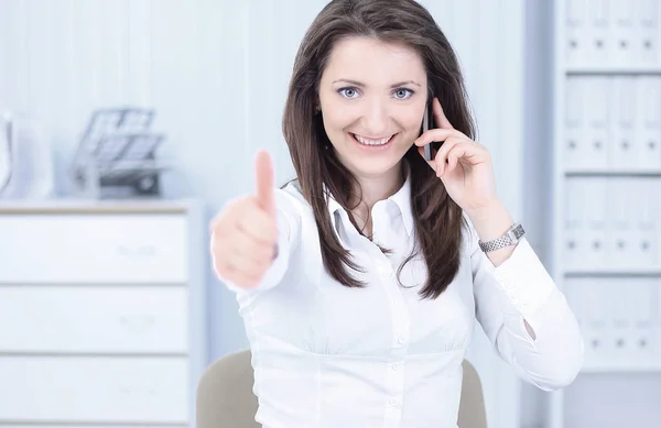 Employee of the company showing thumb up in the workplace — Stock Photo, Image