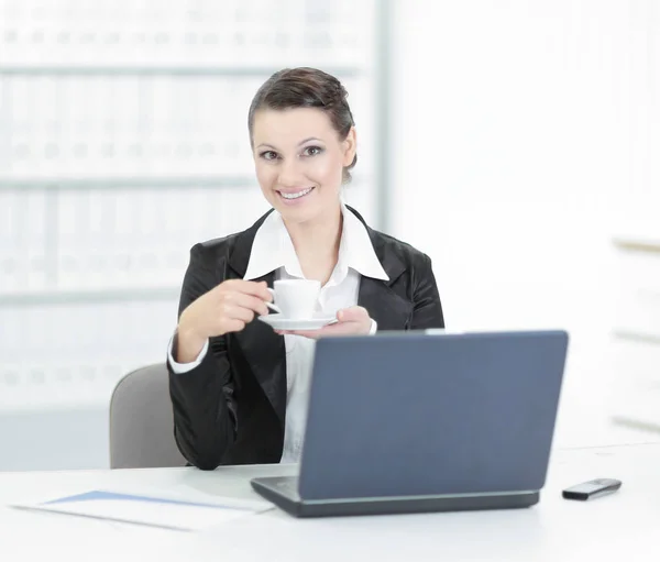 Mujer ejecutiva de negocios con taza de café sentada en su escritorio —  Fotos de Stock