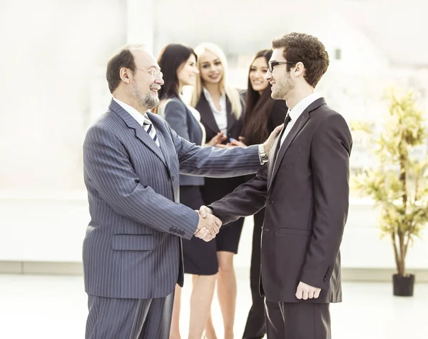 Handshake kollegor i den rymliga lobbyn på kontoret — Stockfoto