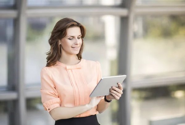 Başarılı iş kadını ile modern bir ofis lobisinde dijital tablet ayakta — Stok fotoğraf