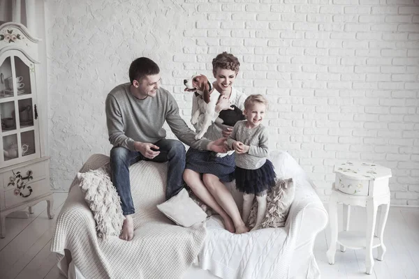 Retrato de familia feliz con perro mascota en el sofá en la sala de estar — Foto de Stock