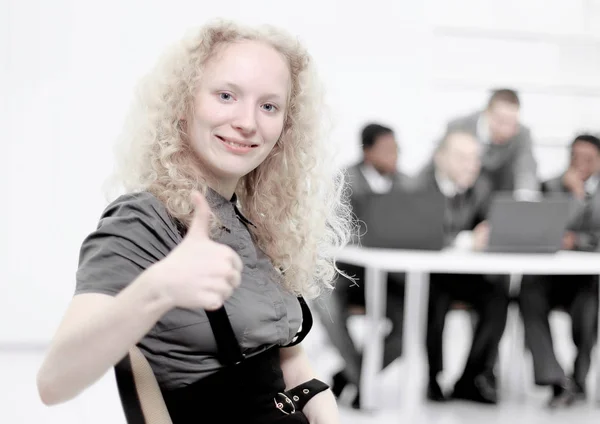 Young female assistant showing thumb up standing in the office — Stock Photo, Image