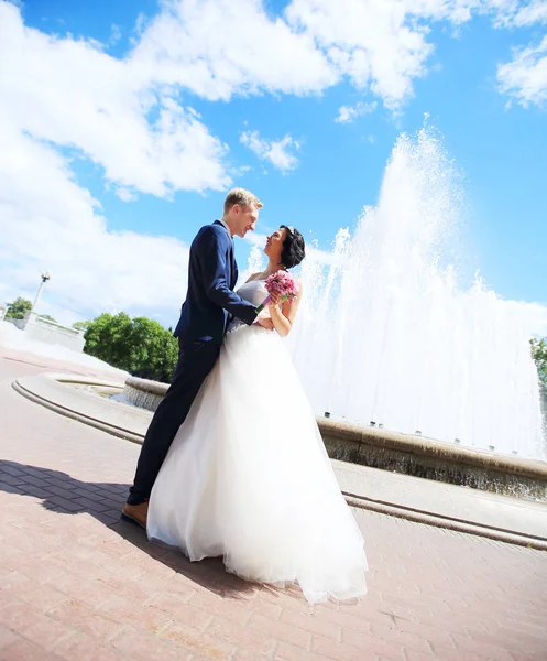 Lyckligt par brudgummen och bruden på bakgrunden av staden — Stockfoto