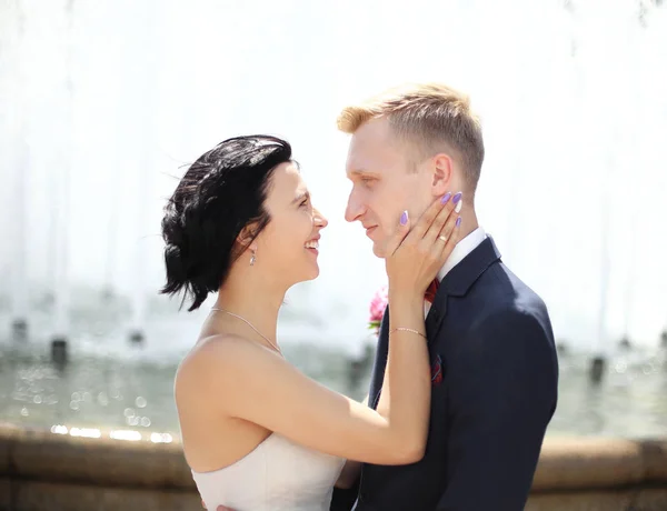 Portrait rapproché de mariée et marié debout à côté de la fontaine — Photo