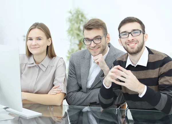 Χαμογελαστή επιχειρηματική ομάδα κάθεται στο γραφείο — Φωτογραφία Αρχείου
