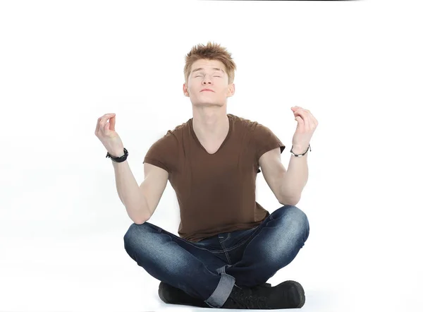 Современный парень медитирует сидя на полу — стоковое фото