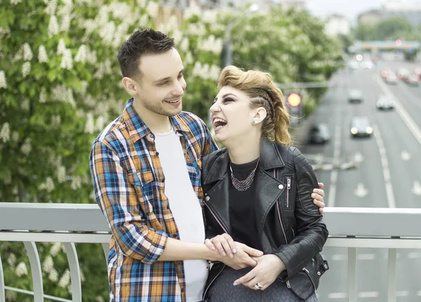 Portrait of loving couple standing on bridge in big city — Stock Photo, Image