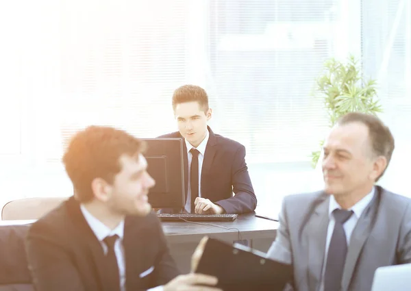 Jefe y empleado discutiendo el documento sentado en el escritorio en la oficina . — Foto de Stock