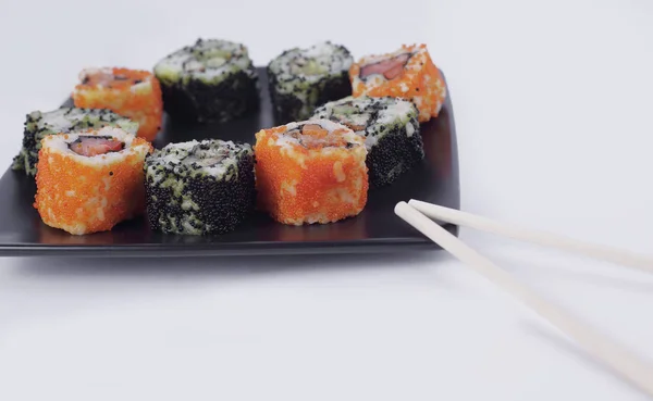 Sushi seti - Maki sushi siyah bir plaka üzerinde farklı türleri. — Stok fotoğraf