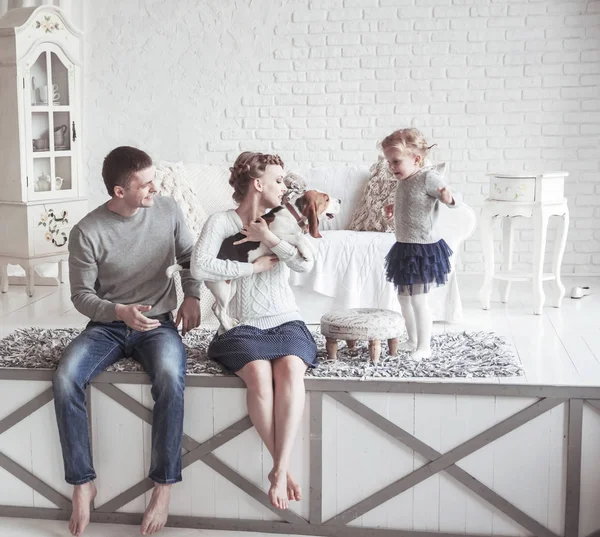 Portrét šťastné rodiny a jejich mazlíčka v útulném obývacím pokoji — Stock fotografie