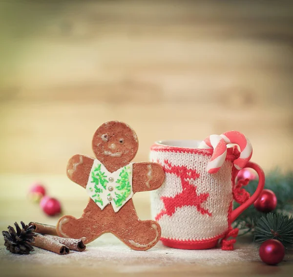 Enfeite de Natal Cup e um divertido pão de gengibre em uma mesa de madeira — Fotografia de Stock