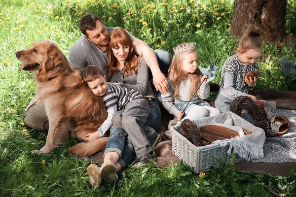 Familia amigable y alegre en un picnic con un perro —  Fotos de Stock