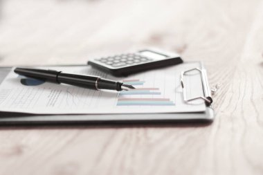 yakın çekim. kalem, hesap makinesi ve ahşap masa panoda. İşletme