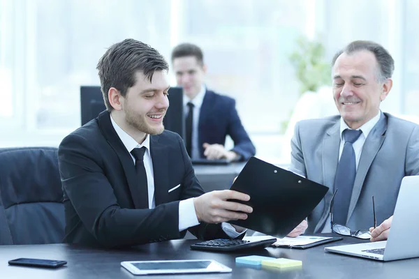 Hombre de negocios adulto discutiendo documentos financieros con un joven colega . — Foto de Stock