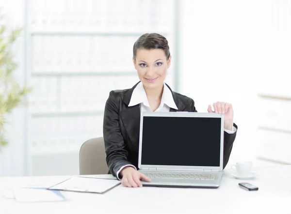 Ejecutiva mujer de negocios mostrando un ordenador portátil sentado en su escritorio — Foto de Stock