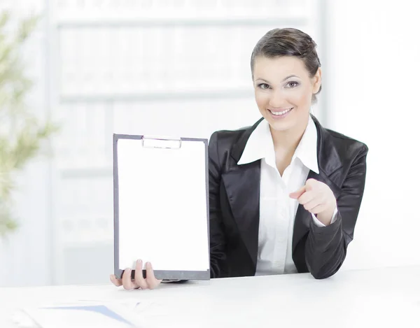 Ejecutiva mujer de negocios mostrando hoja en blanco, sentada en su escritorio — Foto de Stock