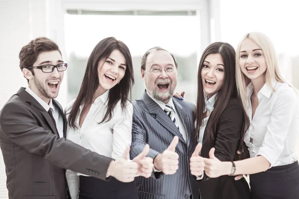 Concept of victory: friendly business team makes a gesture of thumbs up. — Stock Photo, Image