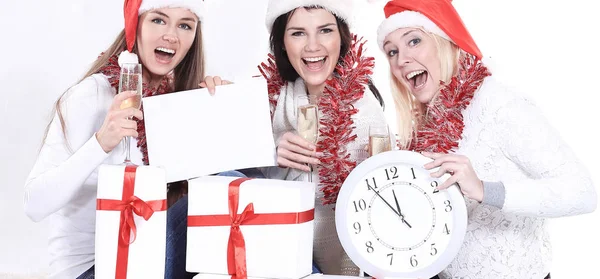 Três jovens mulheres em chapéus de Papai Noel com presentes de Natal f — Fotografia de Stock