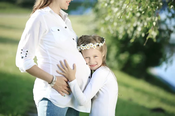 Pojem mateřství - těhotná matka a malou dceru na — Stock fotografie