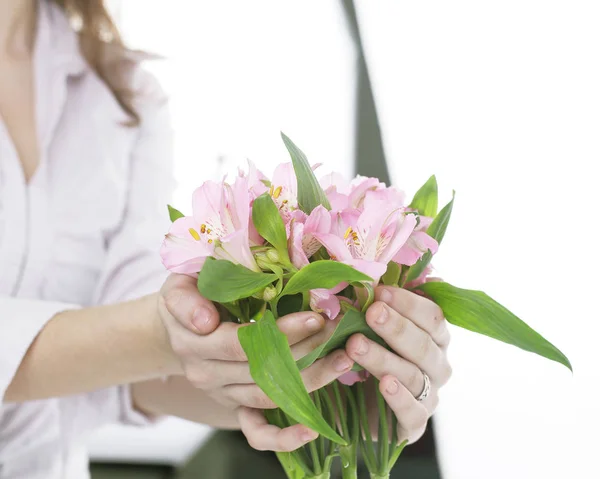 Blumenstrauß in weiblichen Händen isoliert auf einem hellen Hintergrund — Stockfoto