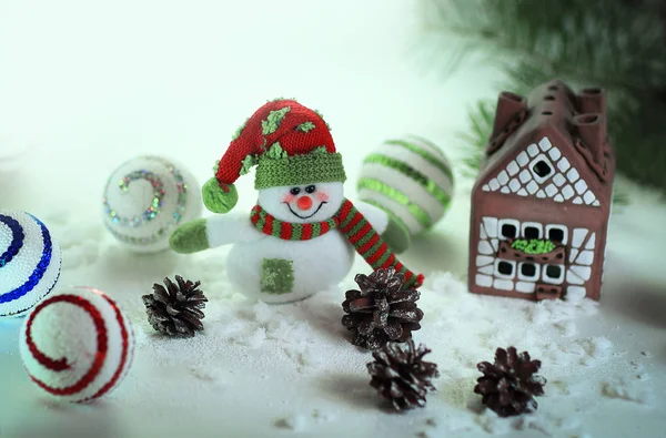 Παιχνίδι χιονάνθρωπος και ένα σπίτι μελόψωμο σε ένα ελαφρύ φόντο. — Φωτογραφία Αρχείου