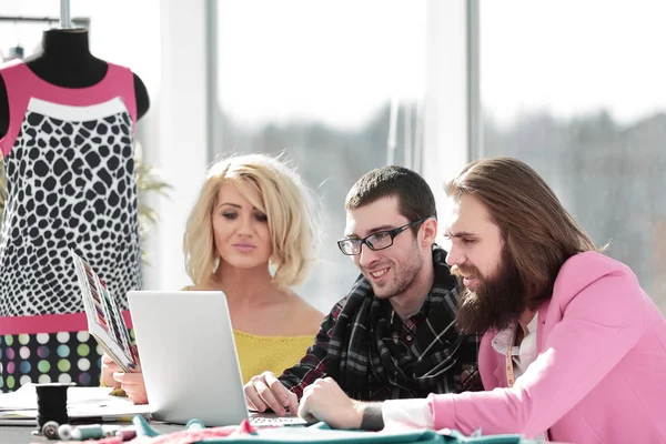 Grupo de designer trabalha em um laptop em um escritório criativo — Fotografia de Stock